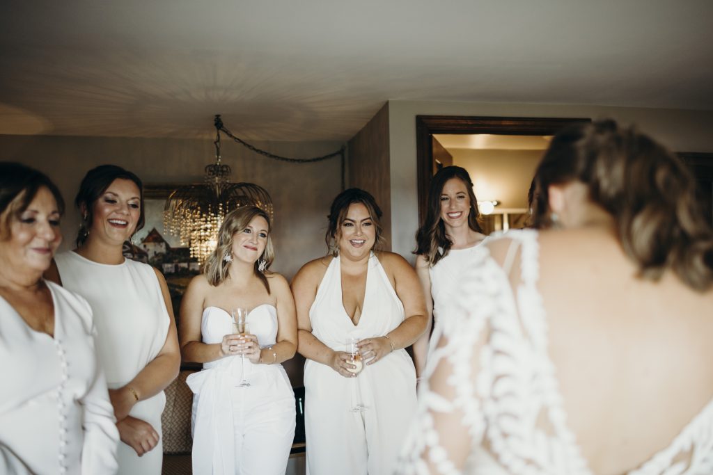 Bridesmaid first look reaction with bridesmaids in jumpsuits