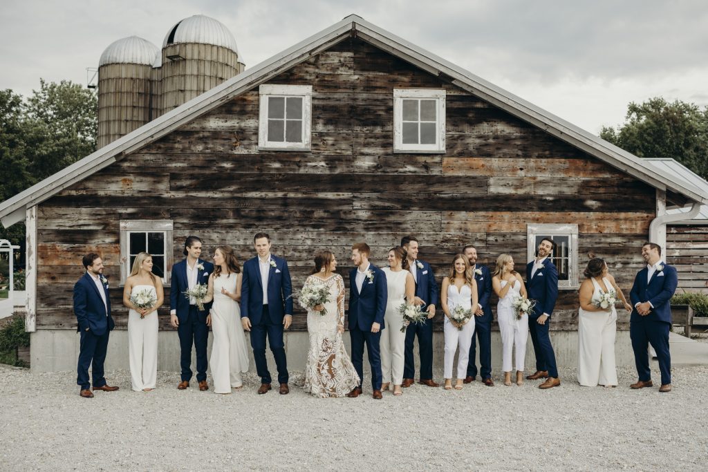 Wedding party goals with jumpsuits and navy suits.