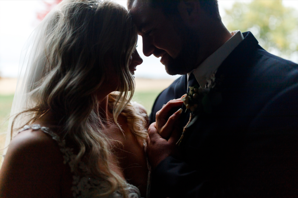 Silhouette shot of bride and groom in their family barn.