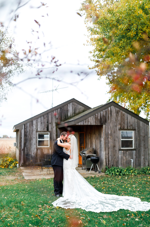 Beautiful Fall wedding portraits with orange tree and wedding dress train.